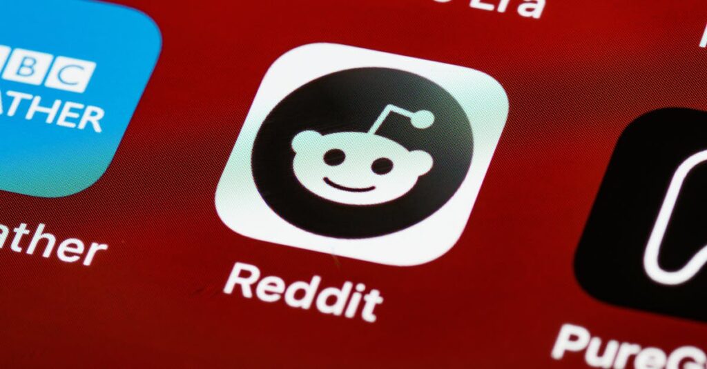 Detailed view of the Reddit app icon on a smartphone screen displaying popular applications.